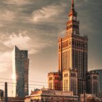 Skyline of Warsaw featuring the Palace of Culture and Science and Złota 44 at sunset.