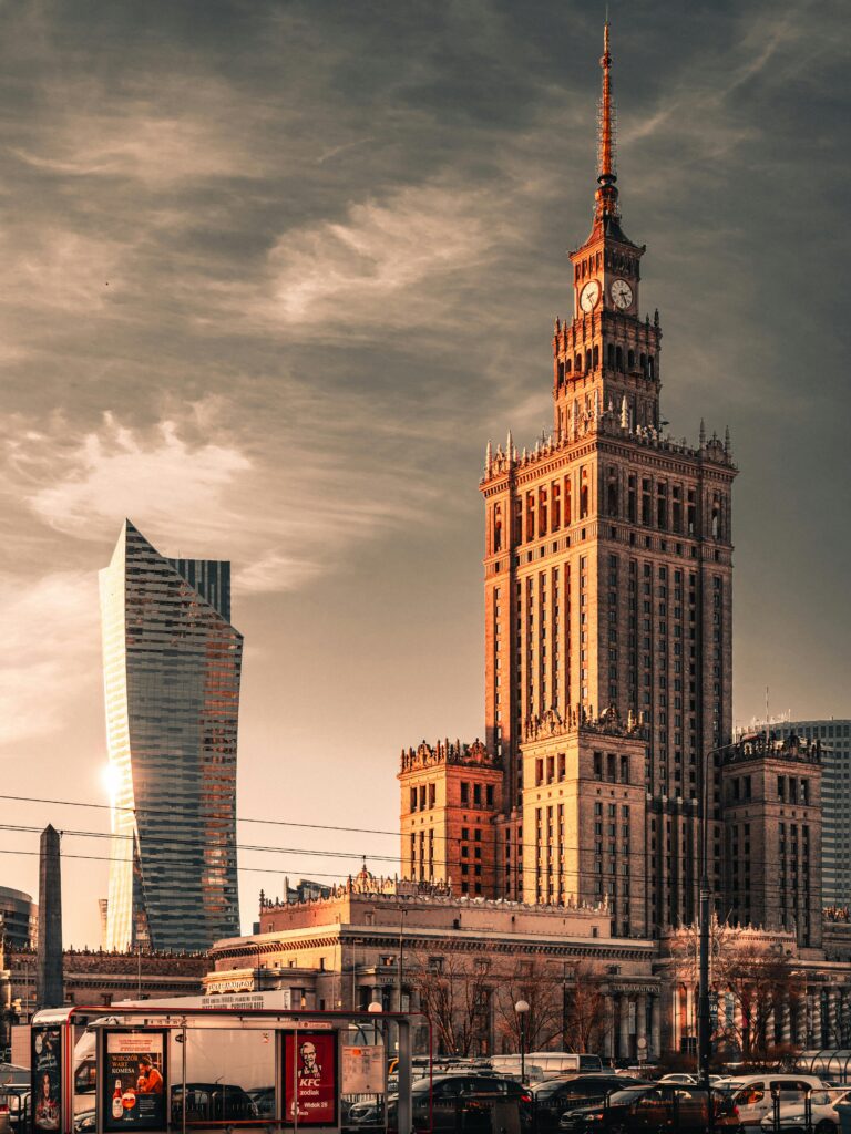 Skyline of Warsaw featuring the Palace of Culture and Science and Złota 44 at sunset.